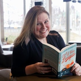 Caroline Richardson holding her book, Out of His League