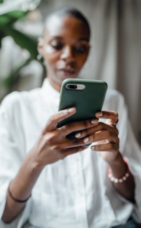 Perosn writing on phone with green phone case